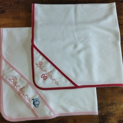 Duas mantas brancas para bebé com bordas rosa e vermelho e nomes bordados