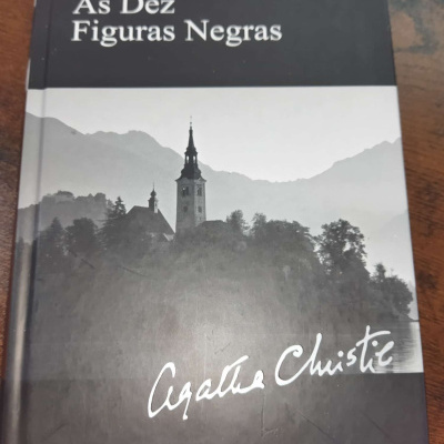Capa de livro preto e cinza com texto e imagem de uma igreja e montanhas