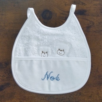 Babete branco com bordados de ursos sorridentes e o nome 'Noé' em azul.
