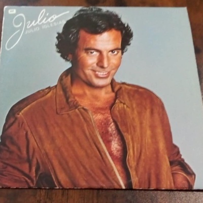 Capa de vinil com homem de jaqueta castanha e texto Julio Iglesias
