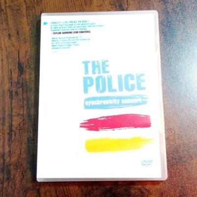 Capa do DVD THE POLICE synchronicity concert com pinceladas vermelha e amarela