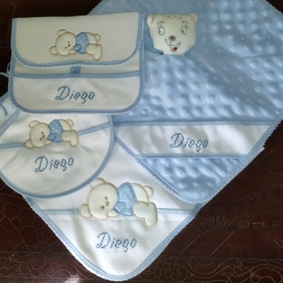 Conjunto de acessórios de bebé brancos e azuis com ursinhos e nome Diego bordado.