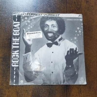 Capa de disco vinil preto e branco com homem de camisa branca e gravata borboleta preta sorrindo