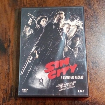 Capa de DVD do filme Sin City A Cidade do Pecado com personagens armados em fundo escuro