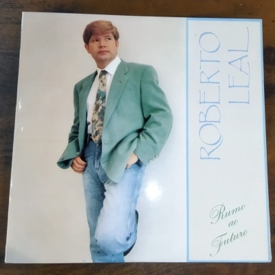 Capa de vinil com homem em casaco verde, jeans azuis e gravata estampada, texto ROBERTTO LEAL e Rumo ao Futuro