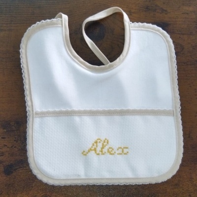 Babete de bebé branco com bordas bege e bordado amarelo