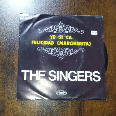 Capa de disco vinil preto com texto amarelo, branco e decorativo cinzento