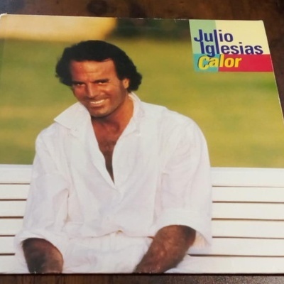 Capa de disco vinil Julio Iglesias Calor com homem de branco sentado num banco branco