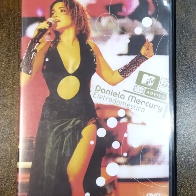 Capa de DVD com Daniela Mercury a cantar em palco com vestido preto