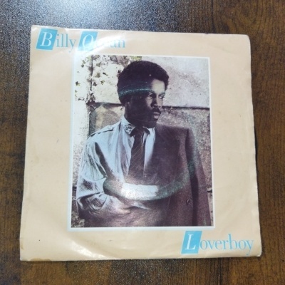 Capa de single em vinil com fotografia a preto e branco de um homem e texto Billy Ocean Loverboy