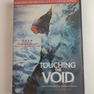Capa de DVD do filme Touching the Void com alpinistas numa paisagem de montanha gelada