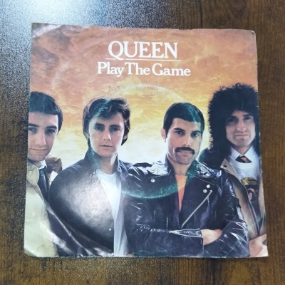Capa de vinil da banda Queen com o título Play The Game
