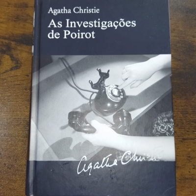 Capa do livro As Investigações de Poirot de Agatha Christie com imagem a preto e branco de um telefone antigo