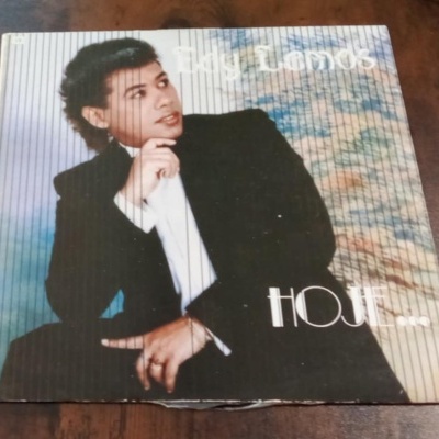 Capa de vinil com homem de fato preto e texto HOJE...