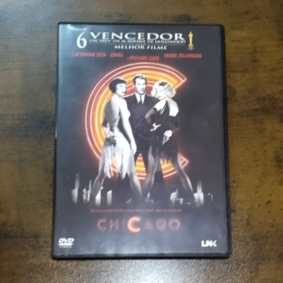 Capa do DVD do filme Chicago com três personagens em roupa de gala sobre fundo preto
