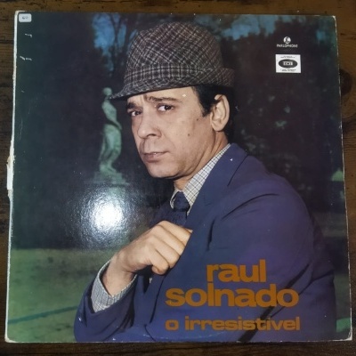 Capa de disco com homem de casaco azul e chapéu quadriculado