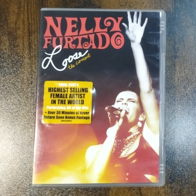 Capa de DVD com Nelly Furtado a cantar e texto promocional em autocolante amarelo