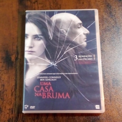Capa DVD filme Uma Casa na Bruma com vidro partido e rostos