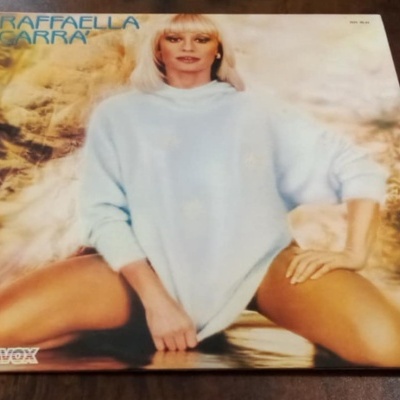 Capa de vinil com mulher loira de camisola azul e texto RAFFAELLA CARRA