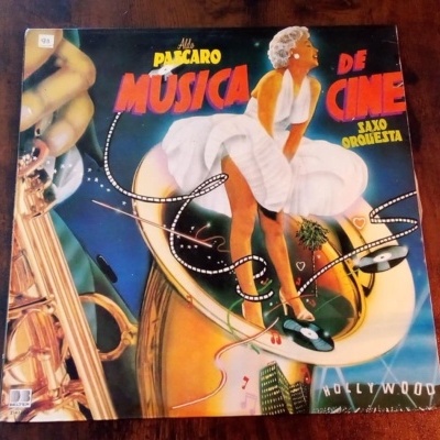 Capa de disco vinil com ilustração colorida de mulher e texto de música de cinema