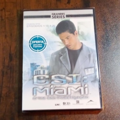 Capa de DVD da série CSI Miami com homem de casaco cinzento e texto promocional