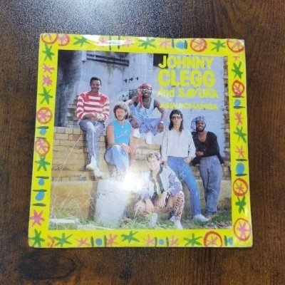 Capa de vinil album musical com moldura amarela e seis homens posando encostados a muro de tijolos.