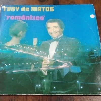 Capa de disco vinil TONY de MATOS romântico com homem de fato preto, mulher de costas e luzes brilhantes em fundo azul.