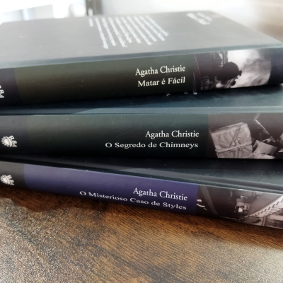 Três livros de Agatha Christie empilhados com títulos visíveis