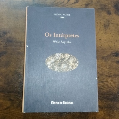 Livro Os Intérpretes de Wole Soyinka com fundo preto e texto referente ao Prémio Nobel 1986.