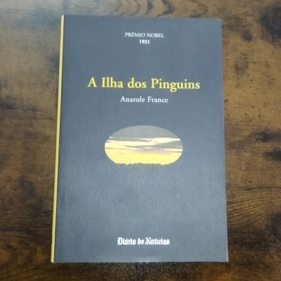 Capa do livro 'A Ilha dos Pinguins' de Anatole France com texto e imagem oval de paisagem