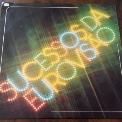 Capa de disco de vinil com iluminação colorida formada por pontos, com palavras SUSCESSO e EU QUERO MAIS