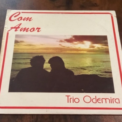 Capa de disco com texto e imagem de silhuetas ao pôr do sol