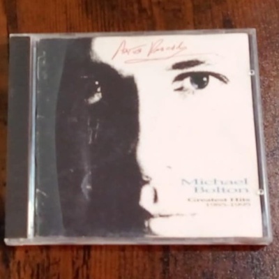 Capa de CD de Michael Bolton com rosto em preto e branco e texto Aves Raras e Greatest Hits Since 1985