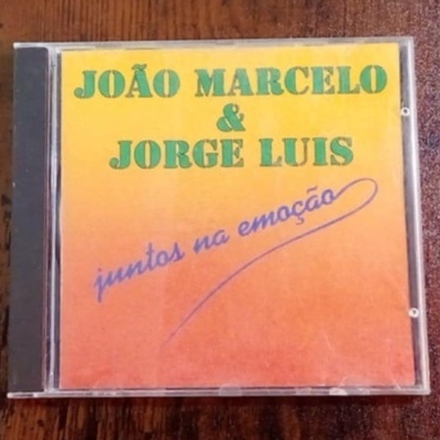Caixa CD com capa amarelo e laranja com texto verde e azul JOÃO MARCELO & JORGE LUIS