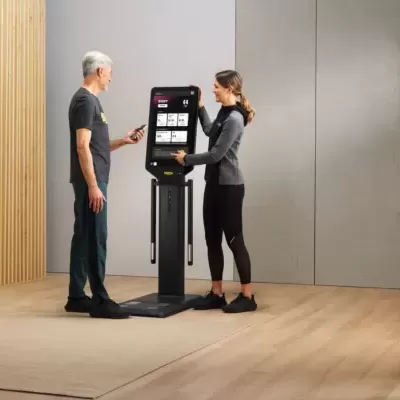 Balança digital com ecrã táctil e pessoas a usar num ambiente interior moderno