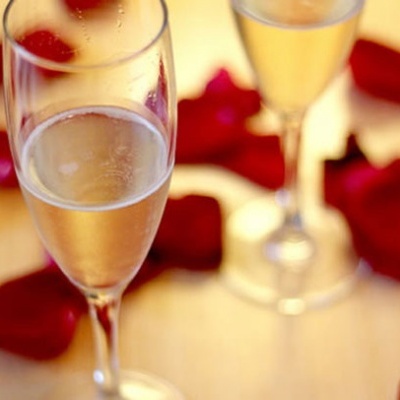 Duas taças de champanhe com pétalas de rosa vermelhas ao redor