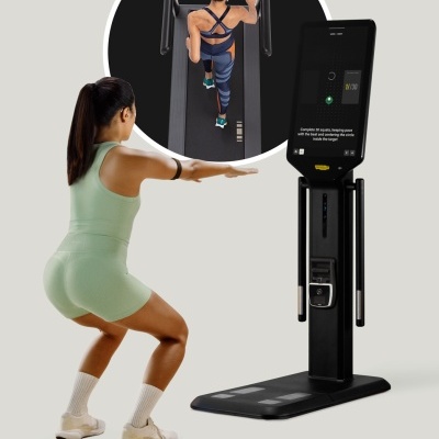 Mulher a fazer exercícios com equipamento de fitness preto e ecrã tátil com instruções em inglês.