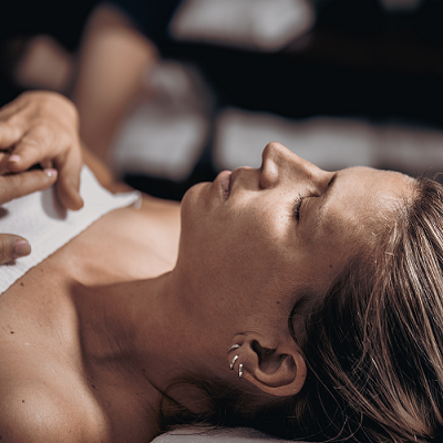 Perfil lateral de mulher com brincos em ambiente desfocado