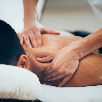 Pessoa a receber massagem nas costas numa cama de massagem