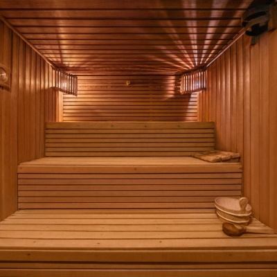 Interior de sauna em madeira clara com bancos e acessórios