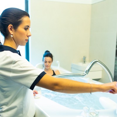 Banheira branca de hidromassagem em clínica com profissional de saúde e paciente