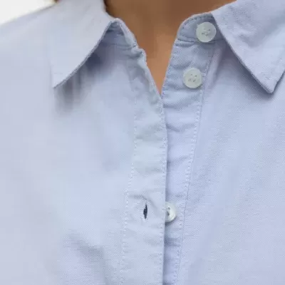 Camisa azul claro com gola e botões brancos