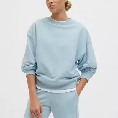 Mulher com roupas desportivas azuis claras e camiseta branca por baixo