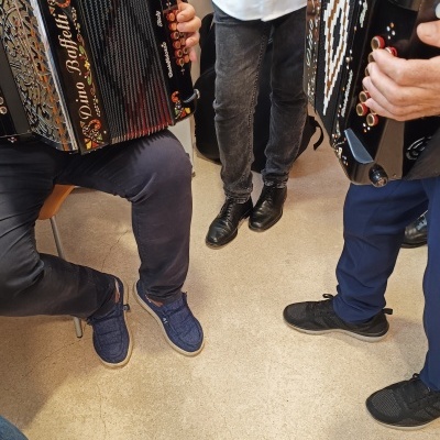 Acordeões decorados em preto com botões e pessoas tocando-os