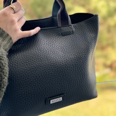 Mala preta de textura granulada com etiqueta AUGUSTA e alças castanhas