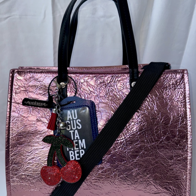 Mala de mão rosa metálica com pendente de cerejas vermelhas brilhantes e alça preta