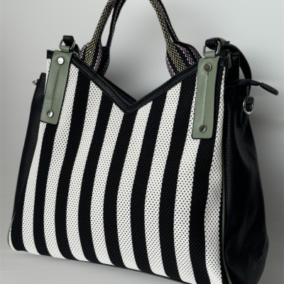 Mala de mão preta e branca às riscas com detalhes verdes
