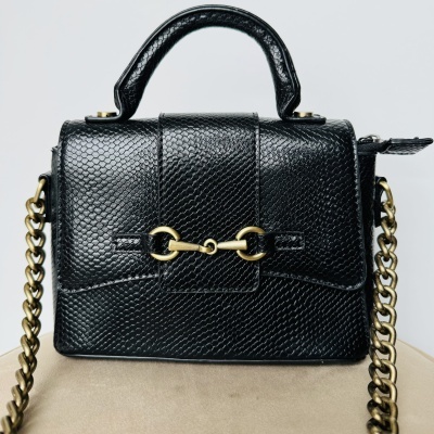 Mala preta com padrão texturizado e alça de corrente dourada