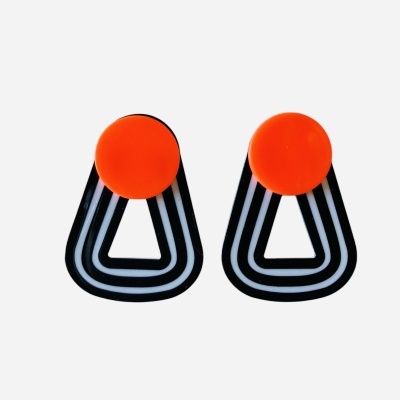 Brincos laranja e preto com padrão branco sobre fundo branco