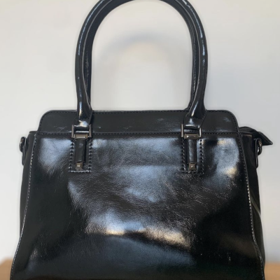 Mala preta de mão em couro sintético com alças e costuras brancas